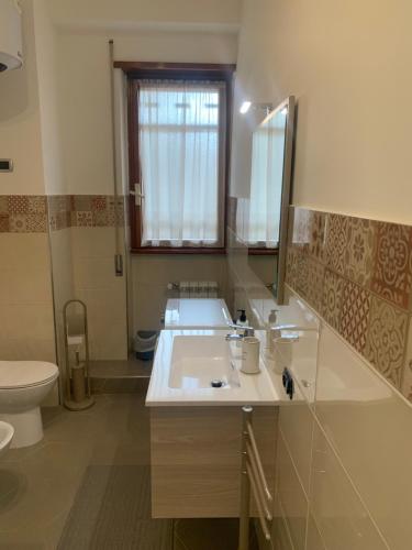 een badkamer met een wastafel, een toilet en een spiegel bij Mostacciano Roma IFO in Rome