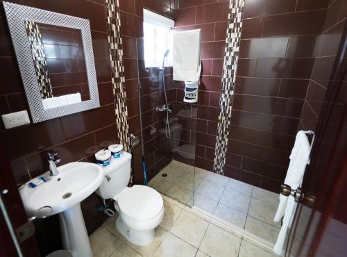 y baño con aseo, lavabo y ducha. en Vibrant 1 Bed 1 Bath with Pool, en Las Flores