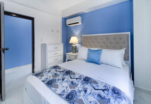 Dormitorio azul con cama y pared azul en Vibrant 1 Bed 1 Bath with Pool, en Las Flores