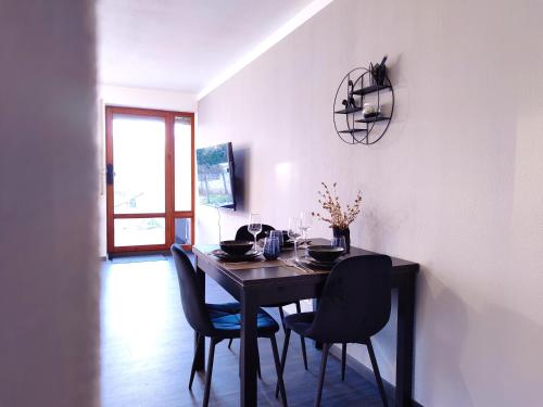 uma sala de jantar com uma mesa com cadeiras e uma janela em Terminal Design Apartment - Terrasse & waipuTV em Steinenbronn