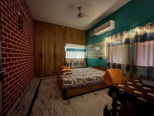 a bedroom with a bed and a brick wall at Amma’s Om stay in Patna