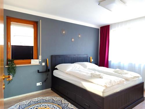 um quarto com uma cama com uma parede azul em Terminal Design Apartment - Terrasse & waipuTV em Steinenbronn