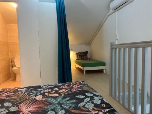 a bedroom with a bed and a stairway with a bed sqor at GITE PEI LA VANILLE Duplex Bord de Nature in Sainte-Suzanne