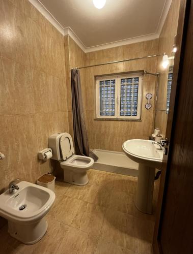 a bathroom with a toilet and a sink at Casa do Eirô in Resende