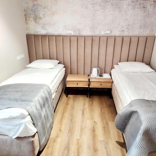 a room with two beds and a wooden floor at Soul House Gdansk Old Town in Gdańsk