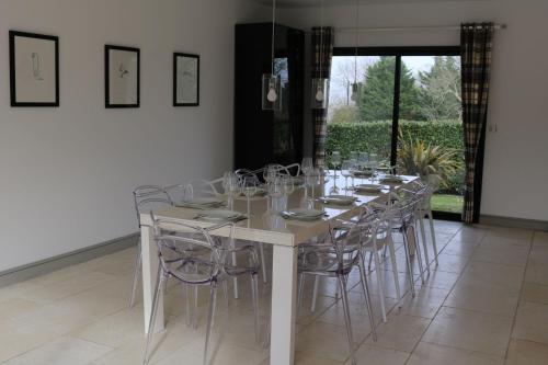 - une table blanche avec des chaises et des verres à vin dans l'établissement Villa La Maringotte, à Honfleur