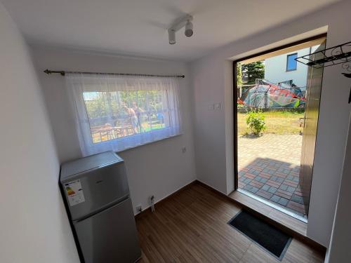 eine Küche mit einem Fenster und einer Tür zum Hof in der Unterkunft Apartament ~ Nad Zatoką in Jastarnia