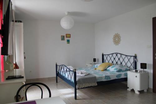 a bedroom with a blue bed and a white wall at Studio Bilka in Komiža