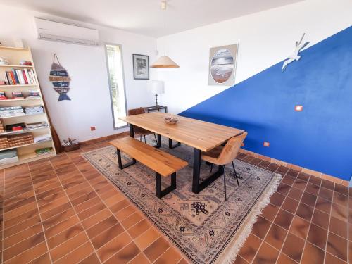 une table et un banc dans une pièce avec un mur bleu dans l'établissement Villa Horizon - 2 chambres avec piscine, au Lavandou