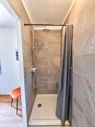 une douche avec un rideau de douche dans une salle de bain dans l'établissement Villa Horizon - 2 chambres avec piscine, au Lavandou