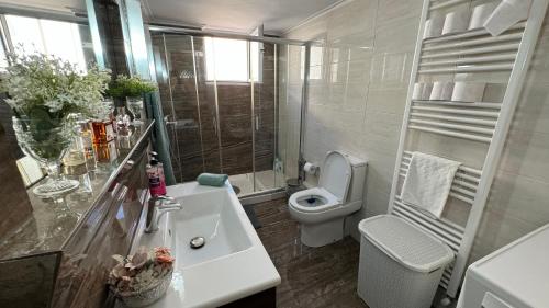 a white bathroom with a toilet and a sink at Kiki's Cozy Casa in Souda