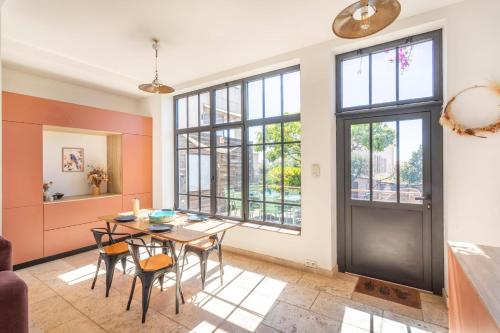 a dining room with a table and chairs and windows at Family home with garden in Toulon - Welkeys in Toulon