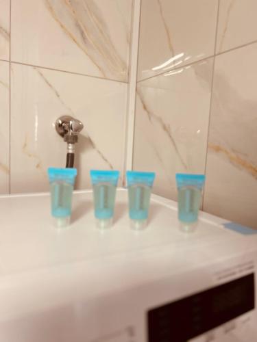 four blue cups sitting on a counter next to a faucet at Central House Karistos Two in Karistos