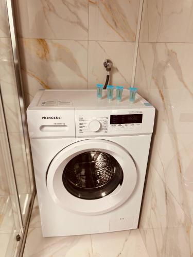 a white washing machine in a corner of a room at Central House Karistos Two in Karistos