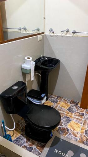 a bathroom with a black toilet and a mirror at Suite de Asdruval in Puerto Baquerizo Moreno