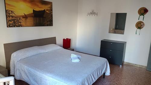 ein Schlafzimmer mit einem Bett und einer Kommode darin in der Unterkunft APPARTAMENTO Fiori di MELOGRANO in Trapani