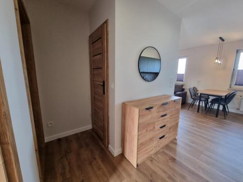 Cette chambre comprend une commode et une table avec un miroir. dans l'établissement Apartament w centrum Radomia, à Radom