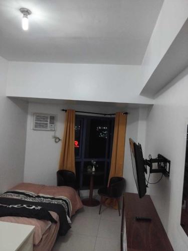 um quarto com duas camas e uma televisão em Grand Riviera Suites em Manila