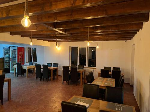 a dining room with wooden tables and chairs at Pensiunea Mara Băile Botiza in Botiza