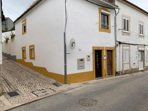 a white building with brown doors on a street at Casa Touriga in Arruda dos Vinhos