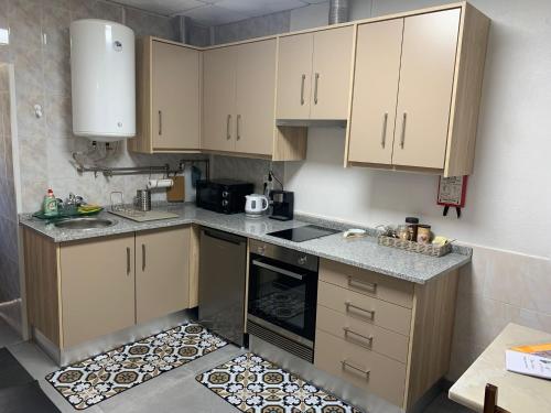 a kitchen with wooden cabinets and a counter top at Casa Touriga in Arruda dos Vinhos