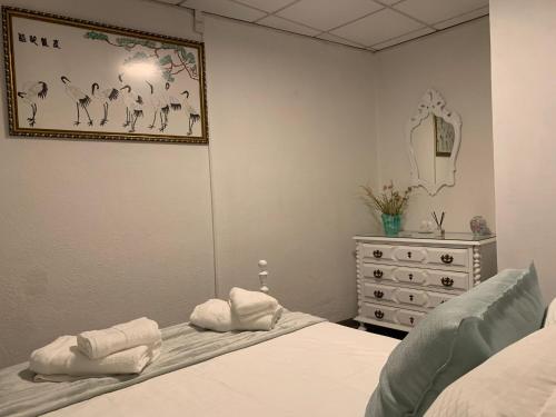- une chambre avec un lit, une commode et un miroir dans l'établissement Casa Touriga, à Arruda dos Vinhos