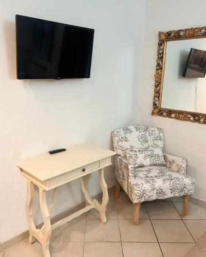 a desk and a chair with a television on a wall at Casa Paradiso in Florence