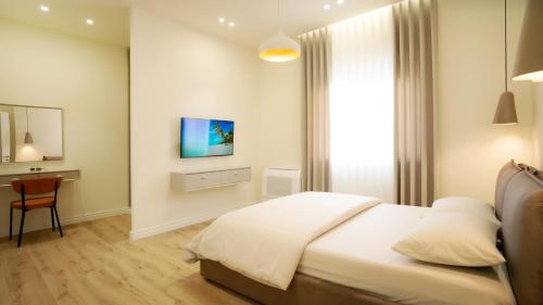 a bedroom with a bed and a desk in it at Cosmo Beach Apartment Deluxe in Durrës