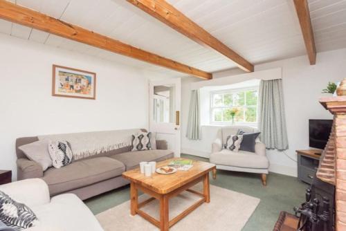uma sala de estar com um sofá e uma mesa em Blue Cottage - 3 bedroom cottage in Feock em Feock