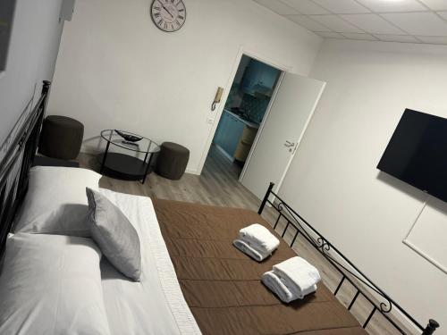 Un dormitorio con una cama y un reloj en la pared. en B&B Clesio & Residence Buonconsiglio Apartments, en Trento