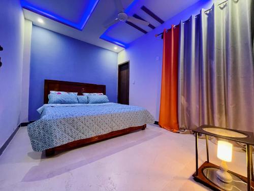 a bedroom with a bed in a blue room at Own It Apartment Brown in Islamabad