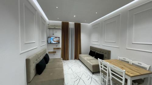 a living room with a table and a couch at Apartments Costa Azzurra in Velipojë
