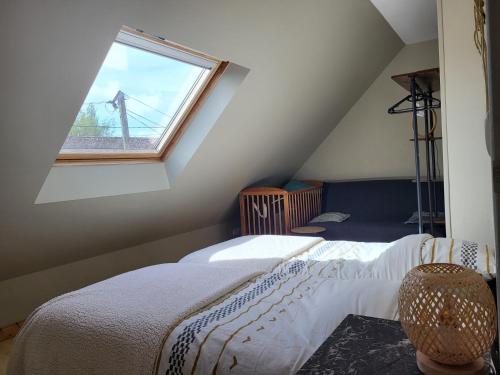 une chambre mansardée avec un lit et une fenêtre dans l'établissement La Massette, à Favières