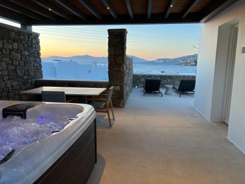 a hot tub on a patio with a view of the ocean at Bonzoe Suites & Villas in Mýkonos City