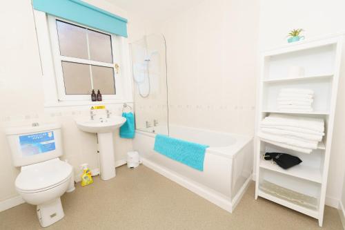 a white bathroom with a toilet and a sink at Achloist Holiday Cottage in Drumbeg