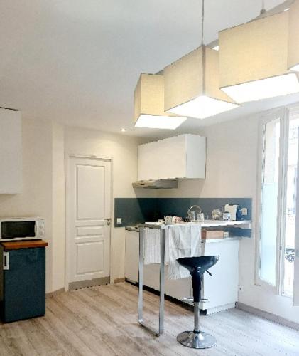 une cuisine avec un comptoir et un tabouret. dans l'établissement Puces de Vanves, à Malakoff