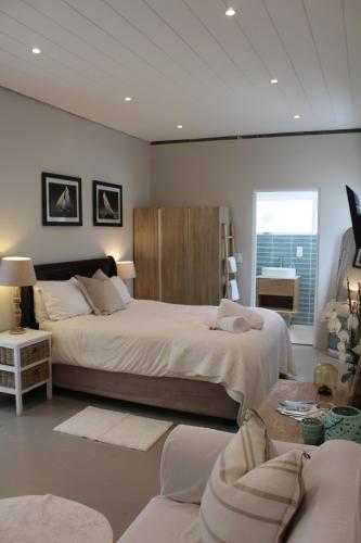sypialnia z dużym łóżkiem i kanapą w obiekcie Sea Breeze Cottage w Kapsztadzie