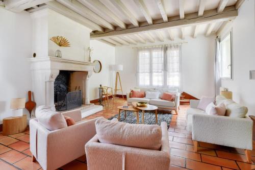 ein Wohnzimmer mit Sofas und einem Kamin in der Unterkunft Bourgeois house and idyllic garden in Le Thuit-Simer