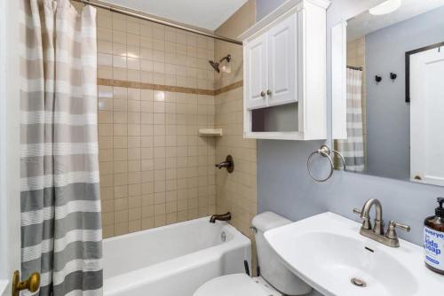 y baño con lavabo, aseo y espejo. en Lovely Cottage w Hot Tub & Grill New River Gorge, en Oak Hill