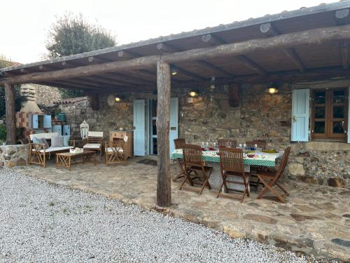 a patio with a table and chairs under a wooden pergola at Stazzo Casa Bianco Fly in Aggius