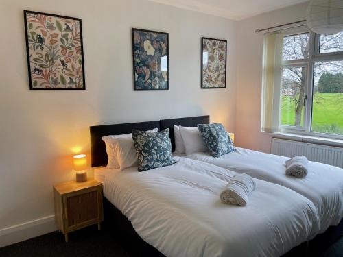 two beds in a bedroom with a lamp on a table at University View-Off-Street Parking-Sleeps 8-Fast WiFi in Nottingham