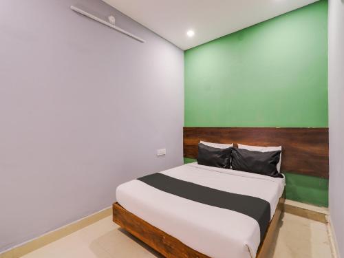 a bedroom with a bed with a green wall at OYO Hotel Ragas in Hyderabad