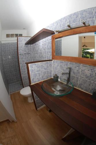 une salle de bain avec un lavabo et un miroir et des toilettes dans l'établissement Appartement, à Biguglia
