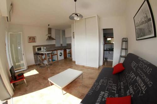 una sala de estar con un sofá y una mesa en Appartement, en Biguglia