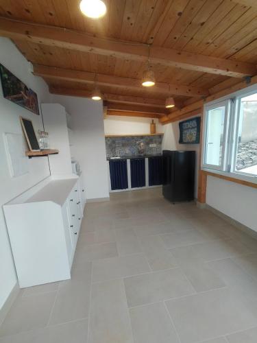 a kitchen with white cabinets and a wooden ceiling at Vicol8Netino in Noto