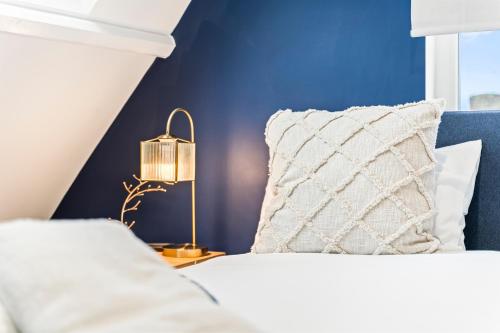sypialnia z niebieskimi ścianami i łóżkiem z poduszką w obiekcie Bowles Aparthotel by Yoko Property w mieście Redcar