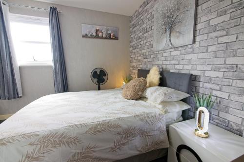 a bedroom with a bed and a brick wall at Stunning 2-Bed Apartment in Manchester in Manchester