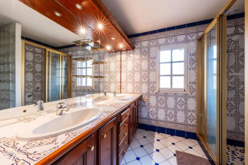 une salle de bain avec deux lavabos et un grand miroir dans l'établissement Maison de famille en Sologne, à Yvoy-le-Marron