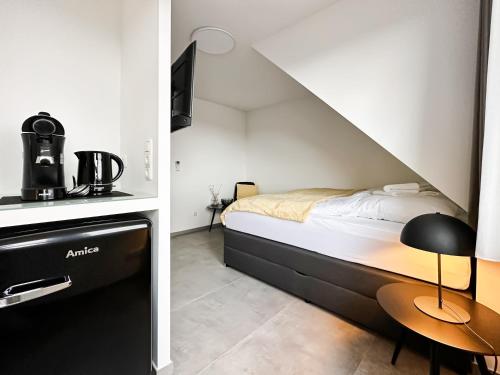 a small bedroom with a bed and a table at SI-View Doppelzimmer mit Stadtblick Zimmer 22 - Hotel in Siegen