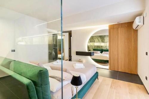 パルティニーコにあるVilla Ginevra Private SPAのベッドと緑のソファが備わる客室です。